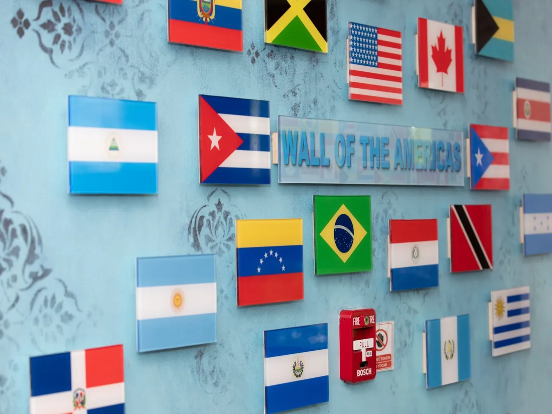The center’s Wall of the Americas, with flags of many countries mounted on a blue wall.
